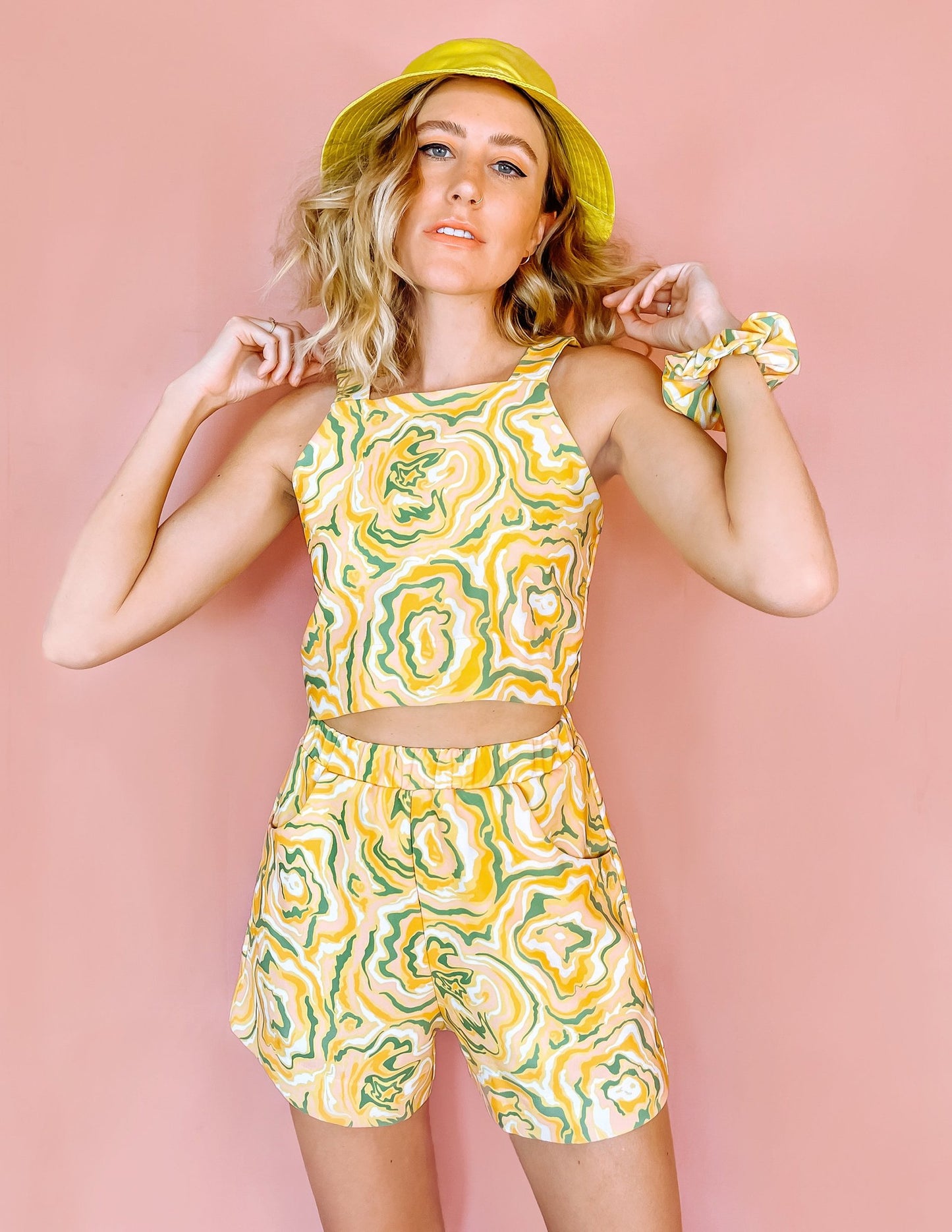 A woman wearing yellow shorts with a green and orange abstract print on it