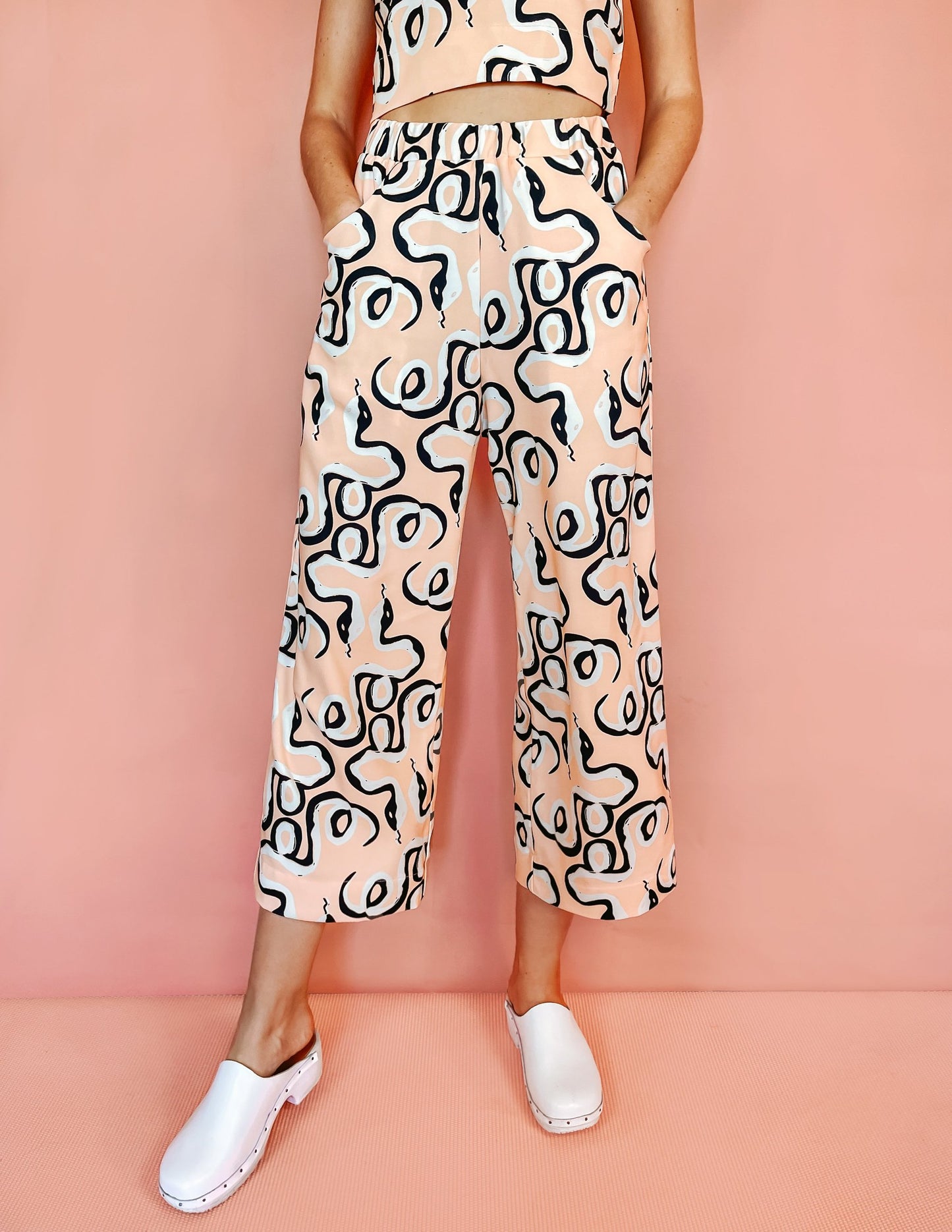 A woman wearing pink short trousers with a black abstract print on it
